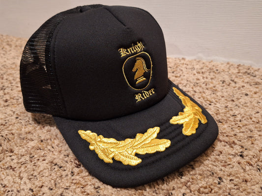 Black cap with gold embroidery on a beige carpet